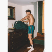 Shirtless man wearing green/blue/yellow stripe slim fit boxers and crew socks.