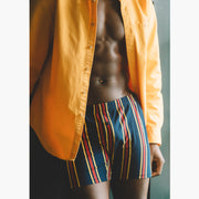 Man wearing yellow/red/blue stripe slim fit boxers and an open yellow dress shirt.