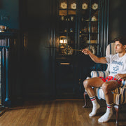 Man sitting in chair wearing red/blue/yellow striped slim fit boxers and blue/red crew socks.