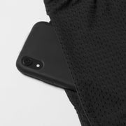 Phone peaking out of pocket lounge shorts with macro texture.