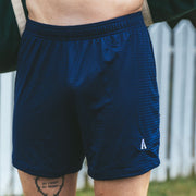 Man standing in front of fence wearing navy blue lounge short with letter "A" monogram