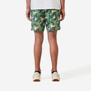 Back view of man wearing pink mesh lounge shorts with palm leafs printed in green.