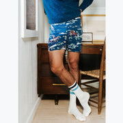 Close up of man standing in bedroom wearing navy blue crewneck and navy slim fit boxers with horses, trees, and clouds.