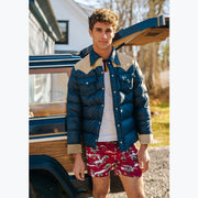 Man standing in front of wagoneer wearing blue jacket and red slim fit boxers with horses, clouds, and trees printed on.