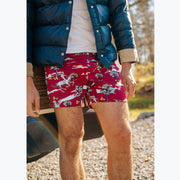 Close up of man standing in front of wagoneer wearing blue jacket and red slim fit boxers with horses, clouds, and trees printed on.