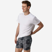 Full body side view of man wearing black bandana slim fit boxers & white t-shirt.