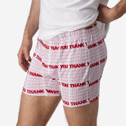 Close up side view of man wearing red & white printed "thank you" slim fit boxers & white t-shirt.