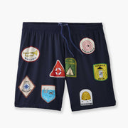 Front shot of blue 'Scout' mesh lounge short with various patch designs printed on.