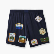 Back shot of blue 'Scout' mesh lounge short with various patch designs printed on.
